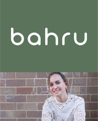 Koala Eco co-founder Jessica Bragdon smiling in a patterned sweater against a brick wall.