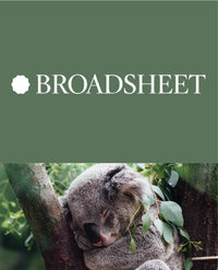 Koala sleeping in a tree among green leaves.