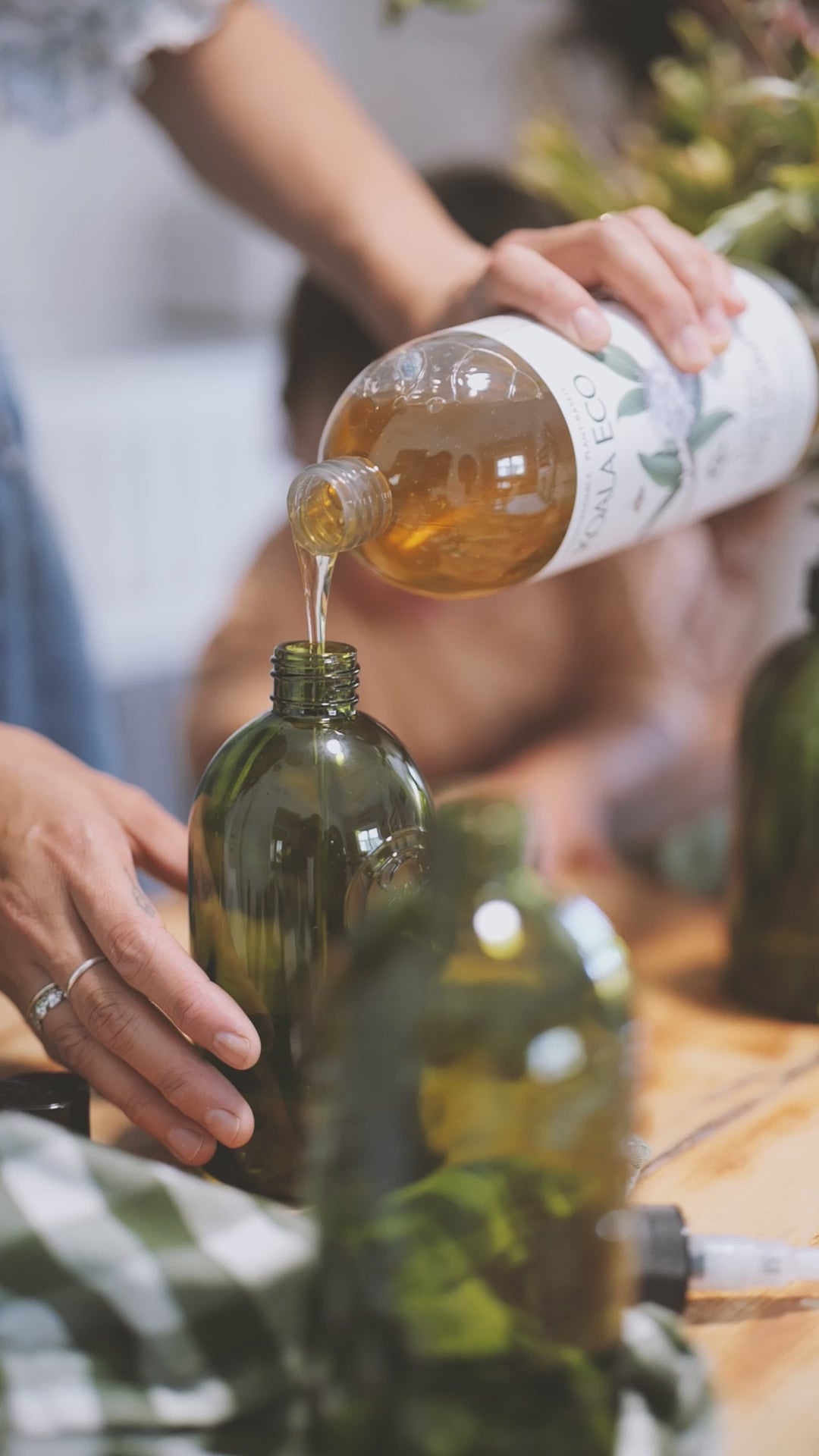 A person refilling a glass bottle with koala Eco product