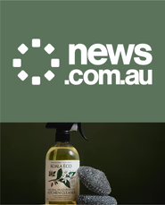 Koala Eco spray bottle with pumice stones on a dark background.